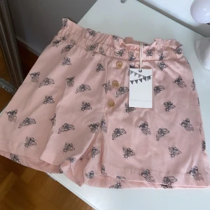 Rosa shorts med flugmönster - Superfina rosa shorts från Boden med ett coolt flugmönster. De har en bekväm elastisk midja och knappar framtill som ger en söt touch. Perfekta för sommardagar eller en avslappnad vårlook. 🦋