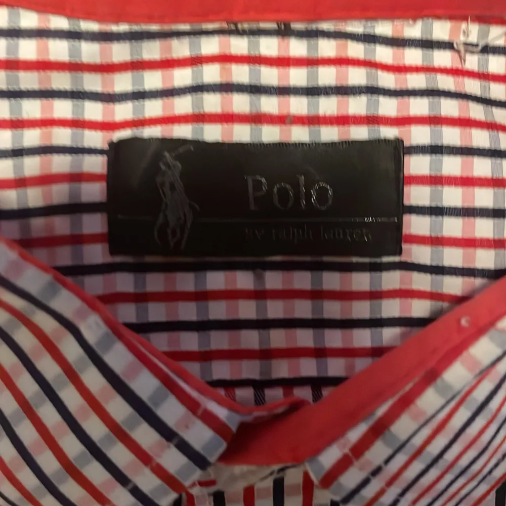 Snygg rutig skjorta från Polo Ralph Lauren i rött, blått och vitt. Perfekt för både vardag och fest! Skjortan har långa ärmar och knappar hela vägen ner. Klassisk krage och en liten broderad logga på bröstet. Passar bra till jeans eller chinos för en stilren look.. Skjortor.