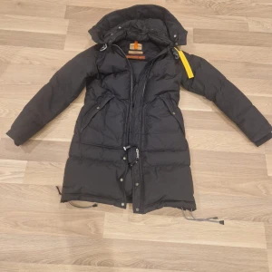  Parajumper dunjacka  - Säljer en svart dunjacka från Parajumpers i storlek small. Jackan har en lång modell med huva och dragkedja framtill. Den är perfekt för vintern och har en cool gul detalj vid halsen. Jackan är i mycket bra skick och sparsamt använd.Ordinarie pris 9200:- 