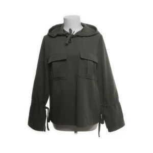 Jacka/ tröja från Emilie Malou  - Säljer en olivgrön jacka eller tröja från Emilie Malou x NA-KD i storlek 34. Jackan har en avslappnad passform med långa ärmar och knytband vid ärmsluten. Den har en huva och två stora fickor framtill. 