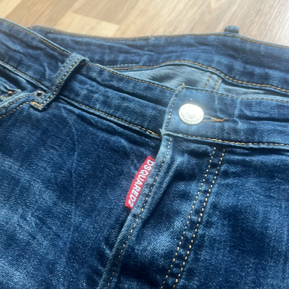 Säljer ett par snygga blå jeans från Dsquared2 med slitna detaljer och en cool DD-logga på bakfickan. De har en knappgylf och är i ett klassiskt jeansmaterial. Hör av er vid intresse!(finns inget kvitto eller så) . Jeans & Byxor.