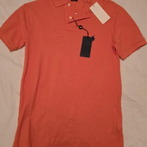 Ralph Lauren pikétröja  - Jag säljer min fina Ralph Lauren pikétröja som inte kommer till användning. Tröjan är i helt nyskick och har även lappen kvar, har inte använts nån gång. Nypris på tröjan är typ 999kr. Säljer den nu för 500kr. Frakt betalas av dig som köpare. 