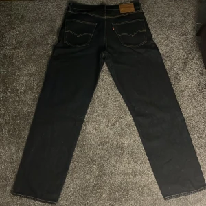 Svarta jeans från Levi's - Säljer ett par klassiska svarta jeans från Levi's i mycket bra skick. De har en straight passform och är högmidjade, vilket ger en snygg och tidlös look. Perfekta för både vardag och fest! (Säljer dem är för små för mig)