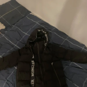 Svart moncler jacka  - Säljer en snygg svart pufferjacka från Moncler. Den är i mycket bra skick och perfekt för vintern. Jackan har en dragkedja och Moncler-loggan syns tydligt på ärmen. Den är långärmad och har en skön passform som håller dig varm under kalla dagar, Betalar ej för frakt