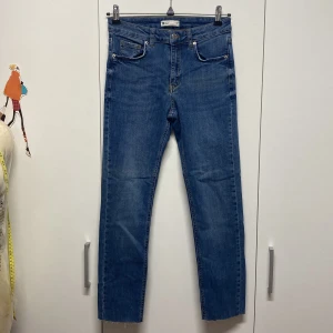 Blå skinny jeans - Säljer ett par klassiska blå jeans från i mycket bra skick. De har en skinny passform och är perfekta för både vardag och fest. Jeansen har en knapp och dragkedja framtill samt fem fickor. Obs: Jag har kortat av dem lite eftersom de var för långa för mig.