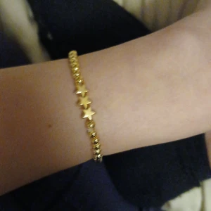 Guldarmband med stjärnor - Snyggt guldarmband med små stjärnor som detaljer. Perfekt för att ge lite extra bling till din outfit. Armbandet är elegant och passar både till vardags och fest. Ett måste för alla som älskar stjärnor och guld!