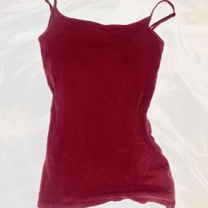 Burgandy linne från Atmosphere - Säljer ett burgandy linne från Atmosphere. Perfekt för vardagsbruk med smala axelband och en enkel design. Passar bra till både jeans och kjol. Ett måste i garderoben för en stilren look!