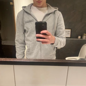 Grå peakperformance hoodie  - Säljer en grå peak hoodie med dragkedja i mycket bra skick. Säljer på grund av att den börjar bli lite liten. Storlek S, nypris runt 1000