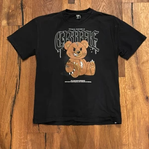 Svart t-shirt med tryck från FSBN - Cool svart t-shirt från FSBN i oversized fit. Den har ett unikt tryck av en tuff nalle med texten 'CREATE' ovanför. Perfekt för en avslappnad stil eller en utekväll med vänner. Tillverkad i Turkiet.