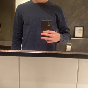 Hugo Boss tröja - Säljer en snygg mörkblå tröja från Hugo Boss i storlek M men den sitter mer som S.  Säljer den för den blivit för liten, lite solblekt kanske men annars väldigt bra skick.  
