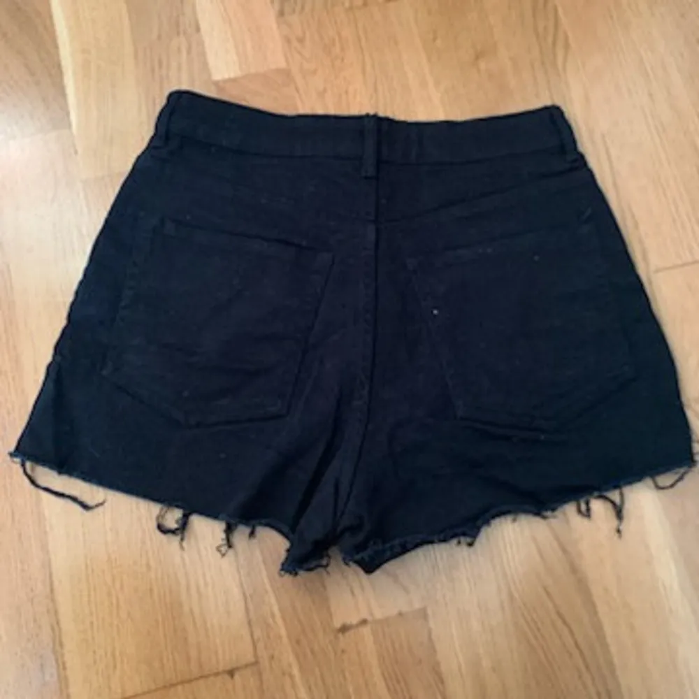 Säljer ett par svarta jeansshorts från Divided i bra skick. De är högmidjade med fransiga kanter och har en klassisk femficksdesign. Perfekta för sommardagar eller festivaler! 🖤. Shorts.