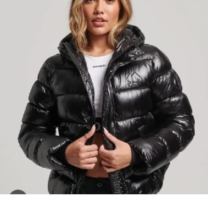 Svart pufferjacka med huva - Säljer en svart pufferjacka från superdry . Den är i bra skick och knappt använd, inga skador. Den är varm och bekväm, perfekt för höst och vinter.