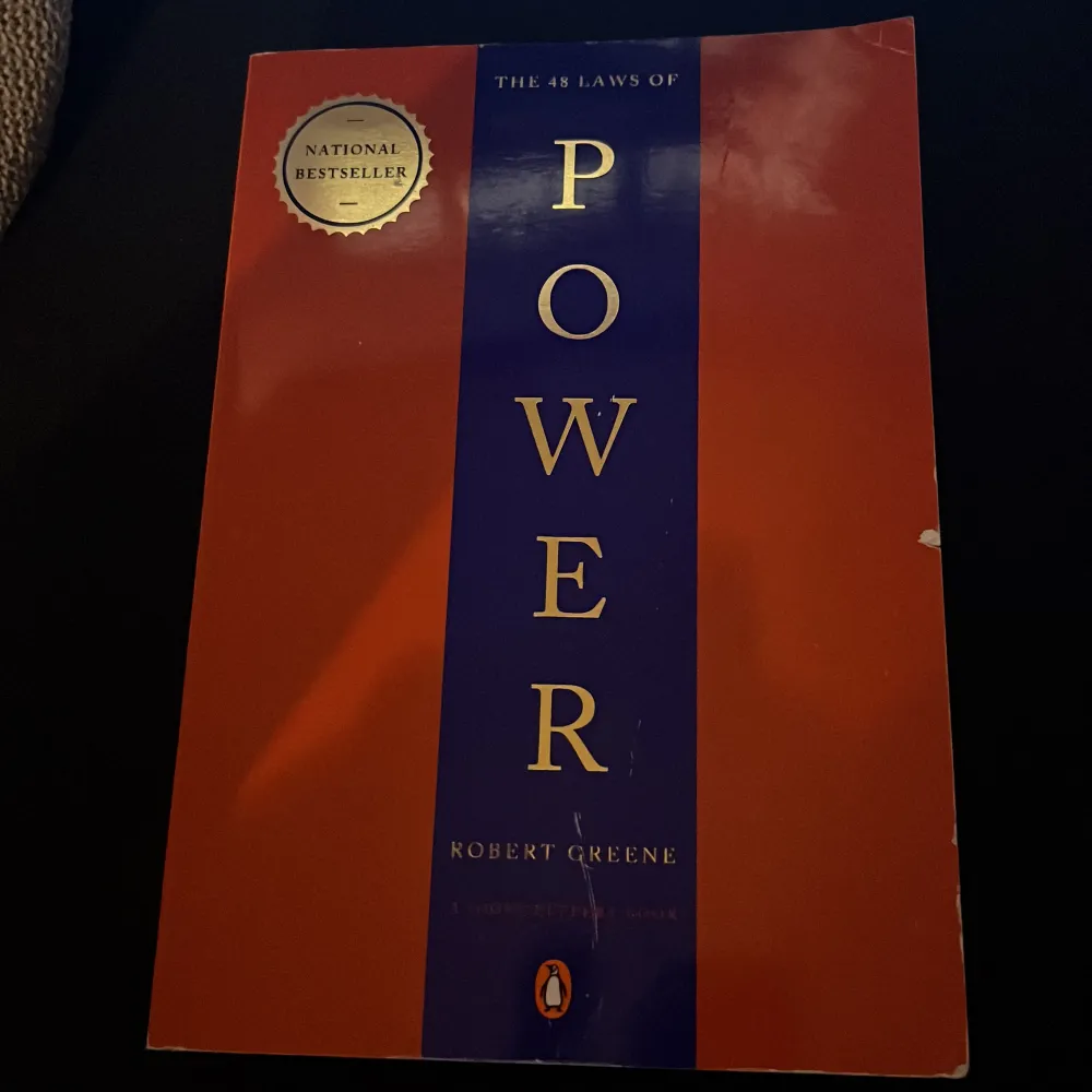 Säljer boken 'The 48 Laws of Power' av Robert Greene. Den har en röd och blå omslagsdesign med guldtext och är en national bestseller. Perfekt för den som är intresserad av strategi och maktspel. Boken är i bra skick med bara några små tecken på användning.. Böcker.