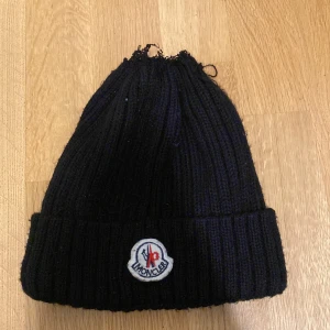  Moncler mössa - Säljer pga av den inte kommer till an ö dig längre den är lite sönder på toppen men går fortfarande och sy ihop de hör av er via frågor eller intresse 
