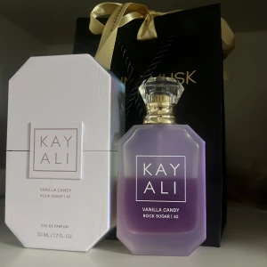 Kayali Vanilla Candy Rock Sugar 42 Eau de Parfum - Säljer en lyxig parfym från Kayali, Vanilla Candy Rock Sugar 42. Doften har noter av kanderat päron, söt viol, bubbelgum, vit karamell, sockerkristall och vaniljkräm. Perfekt för dig som älskar söta och unika dofter! Det ät verkligen en nostalgisk doft 🍭🍬🍨🩷 ca 55% kvar✨