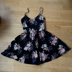 Blommig playsuit h&m - Söt kortklänning med ben (playsuit) Klänningen har smala axelband och en fluffig kjol. Velourmaterial gjord av polyester & elastan 🖤 använd några gånger men i bra skick!!