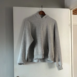 Grå hoodie från Gina Tricot - Säljer en supermysig grå hoodie från Gina Tricot i storlek M. Perfekt för chilliga dagar eller som ett lager under jackan. Den har en klassisk känguruficka och en skön huva. Passar till allt och är i bra skick!