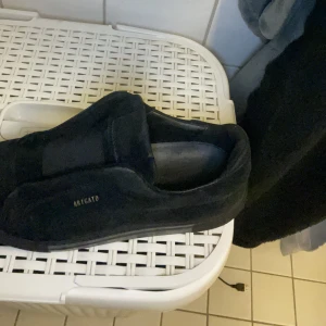 Svarta sneakers från Axel Arigato - Säljer ett par svarta sneakers från Axel Arigato i mocka. De har en stilren design med diskret logga på sidan. Perfekta för både vardag och fest. Skorna är i mycket bra skick och passar till de flesta outfits.