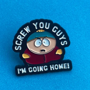 South park pin  - Cool pin med en tecknad figur och texten 'SCREW YOU GUYS, I'M GOING HOME!' i svart och rött. Perfekt för att sätta på jackan eller väskan för en rolig touch. Hämtas i Hornstull i Stockholm eller skickas mot fraktkostnad. 🌟