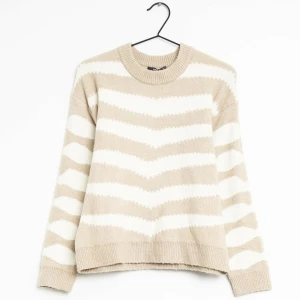 Beige och vit randig stickad tröja - Superfin och mysig stickad tröja i beige och vitt med randigt mönster. Passar även mig som vanligtvis bär S. Perfekt för höst och vinter!  Pris går att diskuteras