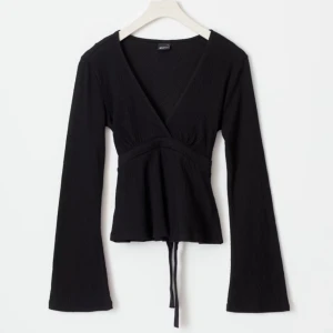 Svart långärmad topp med knyt - Intresse koll på min snygga svarta långärmade topp från Gina. Bra skick använd fåtal gånger💕