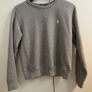 Polo Ralph Lauren Tröja  - Snygg mörkgrå, Polo Ralph Lauren tröja. Storlek s men passar xs. Defekter som visas på bilderna men syns knappast i verkligheten 