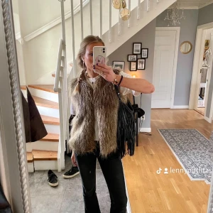 Brun pälsväst - Säljer en snygg brun pälsväst som är perfekt för höst och vinter. Västen har en naturlig look med långa pälsdetaljer och är i mycket bra skick. Den är idealisk för att lägga till lite extra värme och stil till din outfit. Passar bra till både vardag och fest.