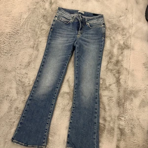 Blå jeans från Hunkydory - Snygga blå jeans från Hunkydory i bootcut-stil. De har en klassisk femficksdesign med dragkedja och knapp framtill. Jeansen har en lätt tvättad look som ger en avslappnad känsla. Perfekta för både vardag och fest!