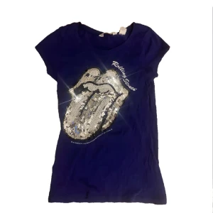 En Rolling stones t- shirt  - En lila Rolling Stones tröja, köpt här på Plick för ett tag sen. Använt ksk 2-3 gånger? Storlek 11-12 så typ Xs. Väldigt fin bara inte min stil längre.