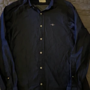 Mörkblå skjorta från GANT - Säljer en snygg mörkblå skjorta från GANT i slim fit. Skjortan har långa ärmar och knappar framtill. Perfekt för både vardag och fest! 🕺nypris 1300