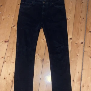 Svarta jeans från Nudie Jeans - Säljer ett par svarta jeans från Nudie Jeans i mycket bra skick. De har en klassisk femficksdesign och är tillverkade i ett slitstarkt denimtyg. Perfekta för både vardag och fest! 🖤