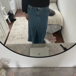 Jeanskjol med slits - Säljer en snygg jeanskjol i klassisk blå färg. Kjolen har en stilren design med en slits framtill som ger en cool touch. Perfekt för både vardag och festliga tillfällen. Passar bra till en stickad tröja eller en enkel t-shirt. 🦋