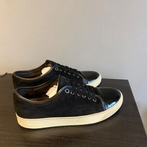 Svarta lanvin skor - Säljer ett par stilrena skor från Lanvin med glans. Skolåda, 2 dustbag och extra skosnöre följer med vid köp. Size 8 vilket motsvarar 42-43. Skick 8,5/10, skriv om du undrar något:) 