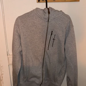Sail Racing Hoodie Grå - En grå sail racing hoodie i bra skick. Använd ungefär 10 gånger. Storlek S men liten i storlek. Hör av dig vid frågor. BÄTTRE pris vid snabb affär;)