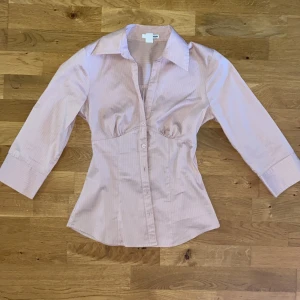 Rosa skjorta  - Rosa skjorta som sitter tajt. Köpte men efter jag fick större bröst sitter den inte bra längre. Rekommenderar till dom med mindre bröst!