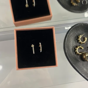 Guldiga örhängen  - Supersnygga guldiga örhängen med silvriga ”stenar” på. Helt oanvända och är i nyskick🥰