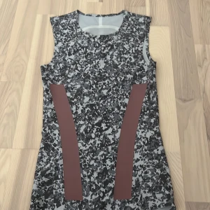 Träningstopp från Adidas - Tajt träningstopp i strl xs. Grå och rosa/lila. Lång så bekväm att träna i. Helt oanvänd, endast prövad. Pris kan diskuteras.