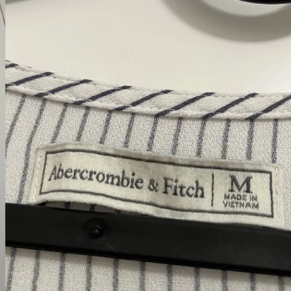 Säljer en snygg randig blus från Abercrombie & Fitch i storlek M. Den har en v-ringad design med korta ärmar och ett omlottmönster framtill. Välanvänd därav priset, org. pris 500kr. Toppar.