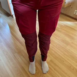 Lundhags byxor - Lundhags byxor i nyskick!  Storlek 34 Färg Röd/Vinröd Modell Mantjeh  Använda fåtal gånger! I nyskick! Kan behövas en tvätt då dom legat nedpackad i låda ett tag!   Perfekt nu till hösten inför jakt, bär/svamp plockande, eller om man är som jag och ä