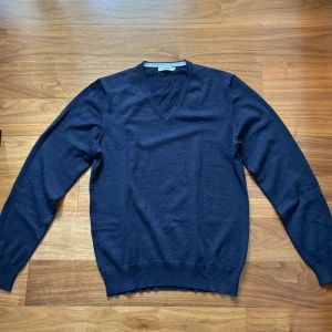 J.Lindeberg tröja - Stilren V-ringad tröja från J.Lindeberg i merinoull. En fantastisk tröja i ett mycket gott skick. Hör av dig för fler funderingar! 