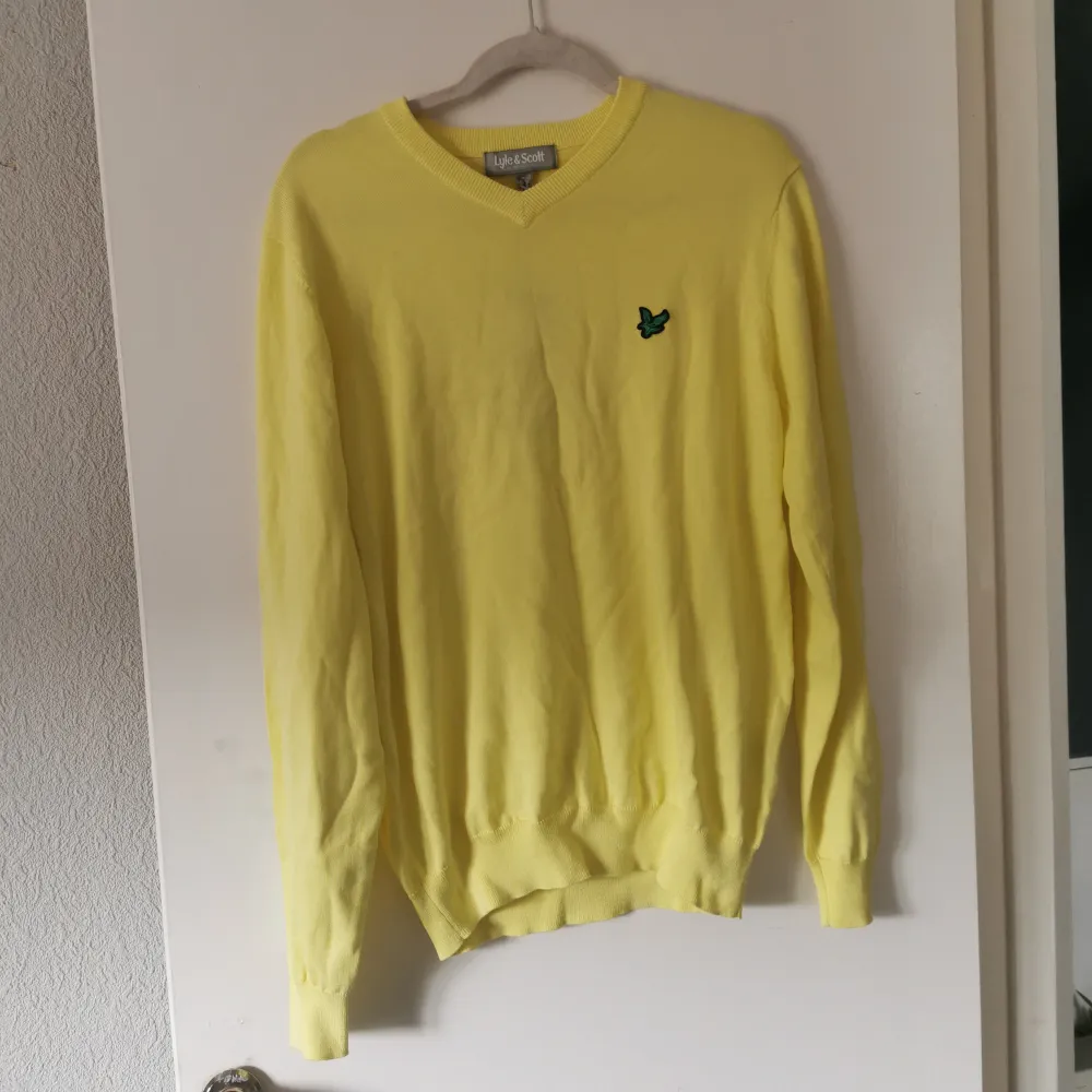 Säljer en snygg gul tröja från Lyle & Scott. Den är i nyskick och har en liten grön logga på bröstet. Tröjan är långärmad och perfekt för vår och sommar. Den är gjord i ett mjukt bomullsmaterial och har en normal passform. Perfekt för en casual look!. Tröjor & Koftor.