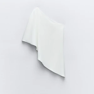 Vit oneshoulder topp - Säljer en stilren vit oneshoulder topp. Den är axelbandslös och har en elegant och enkel design. Passar både till vardags och fest!