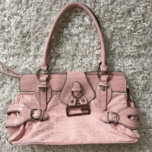 Guess handväska rosa  - Världens snyggaste rosa guess handväska. Flera fack på insidan. Sluts med dragkedja. Köp sker via köp nu, jag postar inom 24h.kvar tills markerad såld 