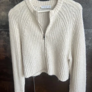 Stickad cardigan - Storlek xs. Stickad kofta med dragkedja i färgen off white . Säljer då den inte kommer till användning.