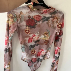 Spetsbody st. s - Spetsbody med ängelmotiv, går upp en aning vid halsen.  Har inte använts så mycket  Skickas nytvättad 