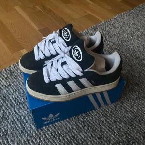 Campus 00s skor - Säljer ett par svarta adidas campus skor i storlek 41 1/2. Skorna köptes i våras och är i mycket bra skick. Inga större defekter. Skriv för fler frågor! 