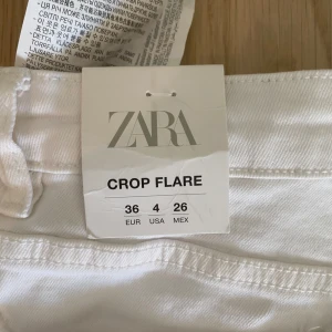 Vita croppade jeans - Trendiga somriga vita jeans, oanvända med prislappen kvar. Byxorna är i Stl S men är ganska små i storleken.