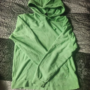 Grön hoodie från SOC - Säljer en fräsch grön hoodie från SOC i storlek M. Den är superbekväm med långa ärmar och en praktisk ficka framtill. Perfekt för både chill och aktivitet. Huvan är skön och ger extra mysfaktor. Passar perfekt till höst och vår!