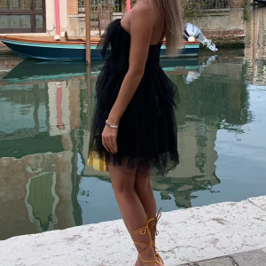 Svart klänning - Svart puffig klänning. Jätte fin och bra i passform tror både xs och mindre M kan använda denna. Använd en gång enbart för bild, alltså nyskick. 