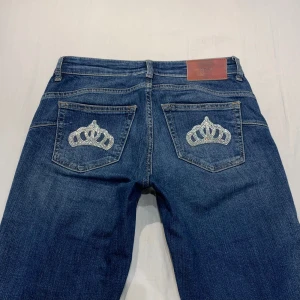 Lågmidjade bootcut jeans💕 - Midja 37 cm rakt över plus stretch, innerben 82 cm o gren 21 cm💕perfekta på mig som är 169 o xs-s. Från Only men satt på egna rhinestones i form av en krona! (Tvättas ut och in)
